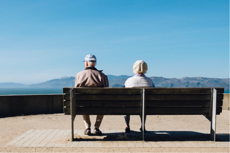 Deux personnes âgées en bonne santé assises sur un banc.